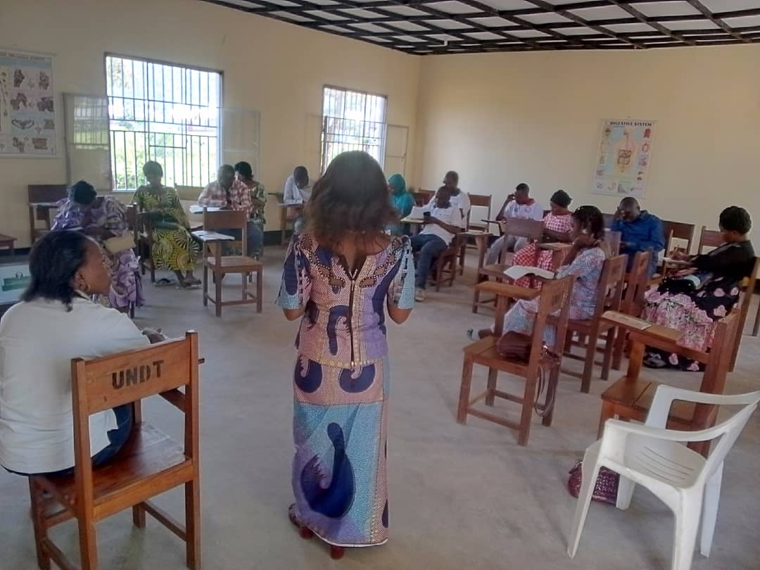 Madame Admin Gestionnaire FEZA OMARI Fely entrain de lire le test et le près test pour évaluer leurs nivaux 